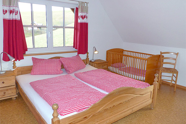 Schlafzimmer mit Doppelbett und Kinderbett